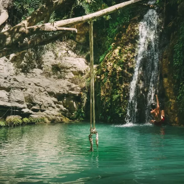 A rope swing visible in the foreground at Aphrodite Baths in Paphos