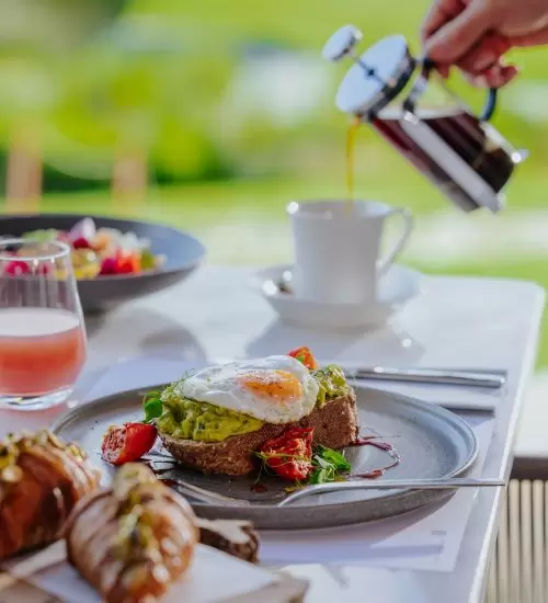An outdoor table is served tea at the Clubhouse restaurant in Minthis Resort