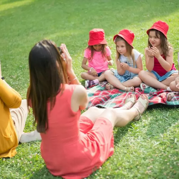 A group of young children play games on the grass at Minthis Resort