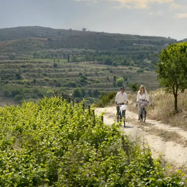 Two guests at Minthis ride pushbikes across a dirt trail at Minthis Resort